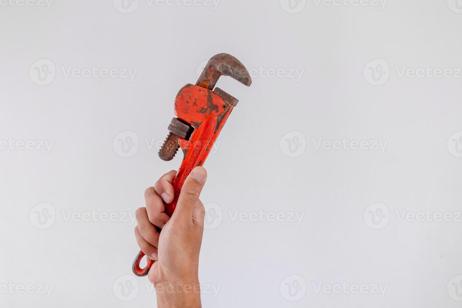 Hand holding a pipe wrench on a white background photo
