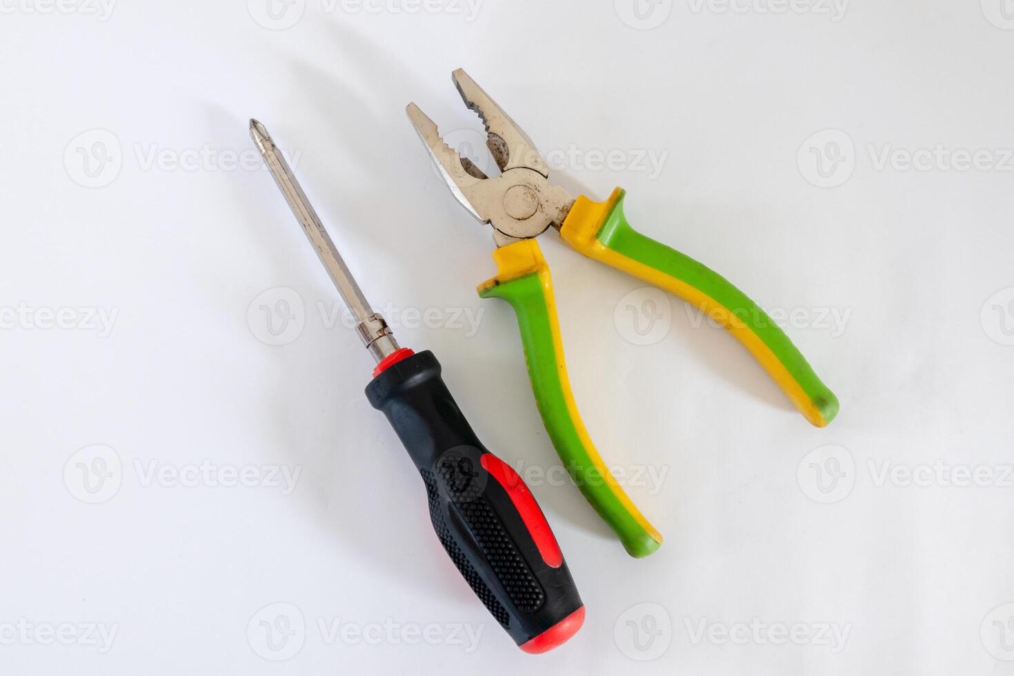 Screwdriver and pliers isolated on white background photo