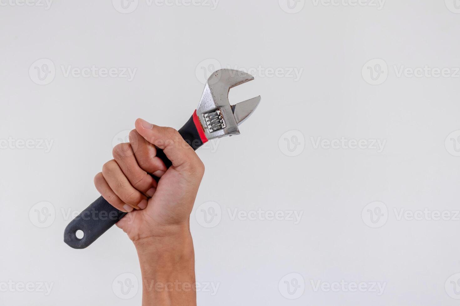Hand holding an adjustable wrench or adjustable spanner isolated on white background photo