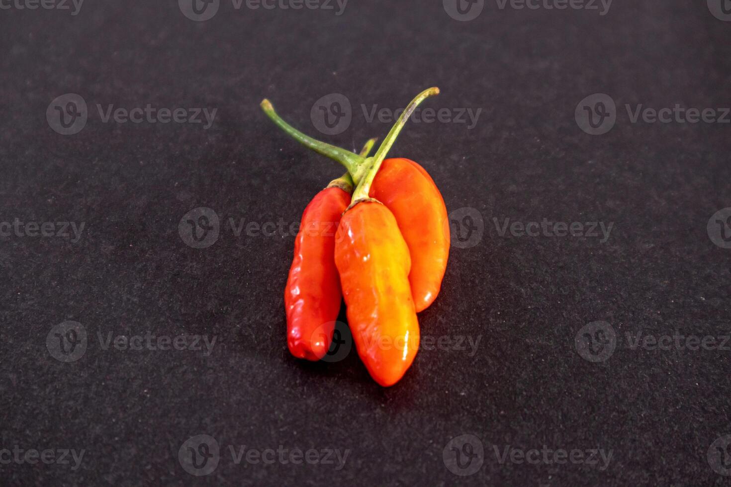 Red cayenne pepper or Capsicum frutescens with very spicy taste isolated on dark background photo