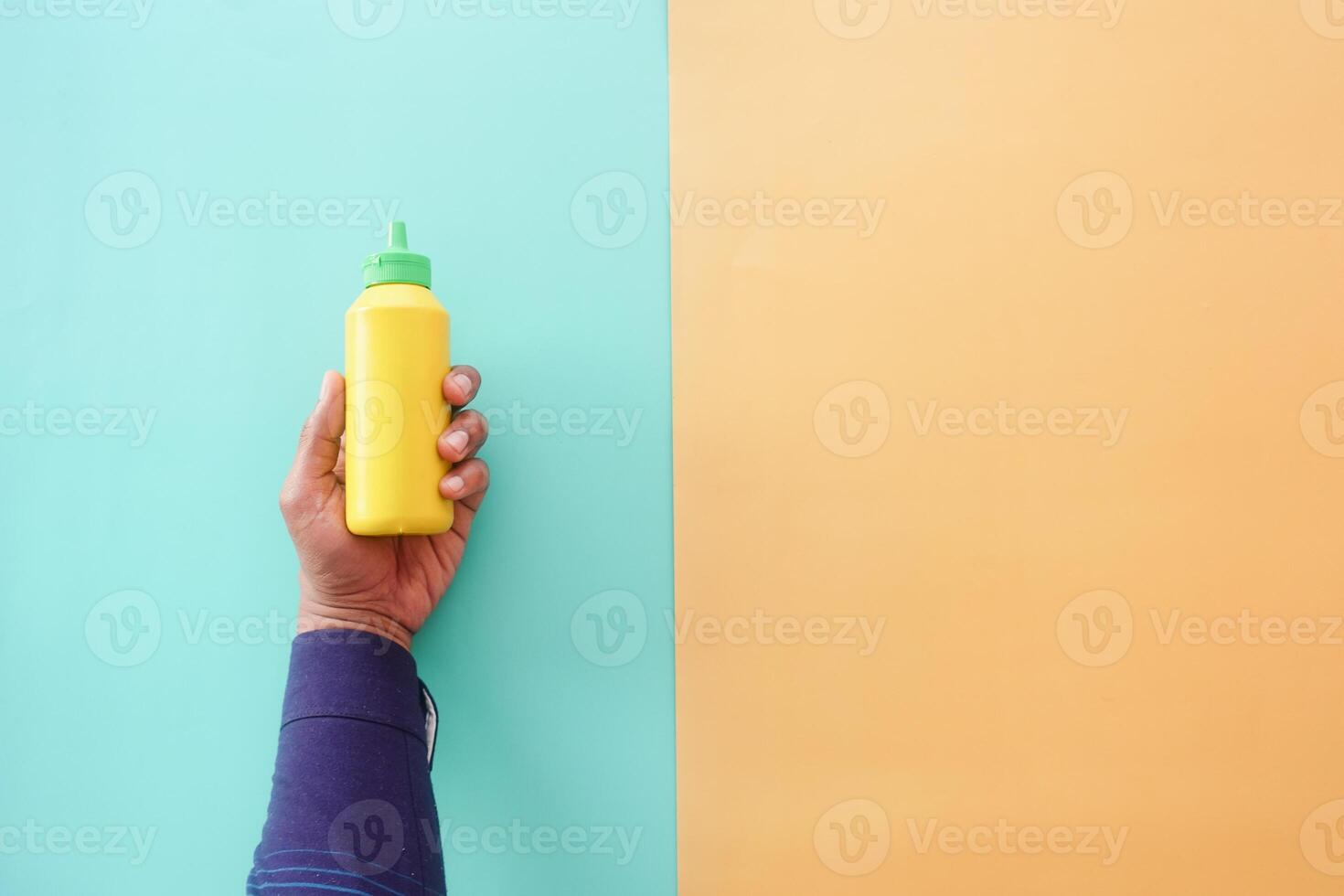 top view of holding a mustard mayonnaise container photo