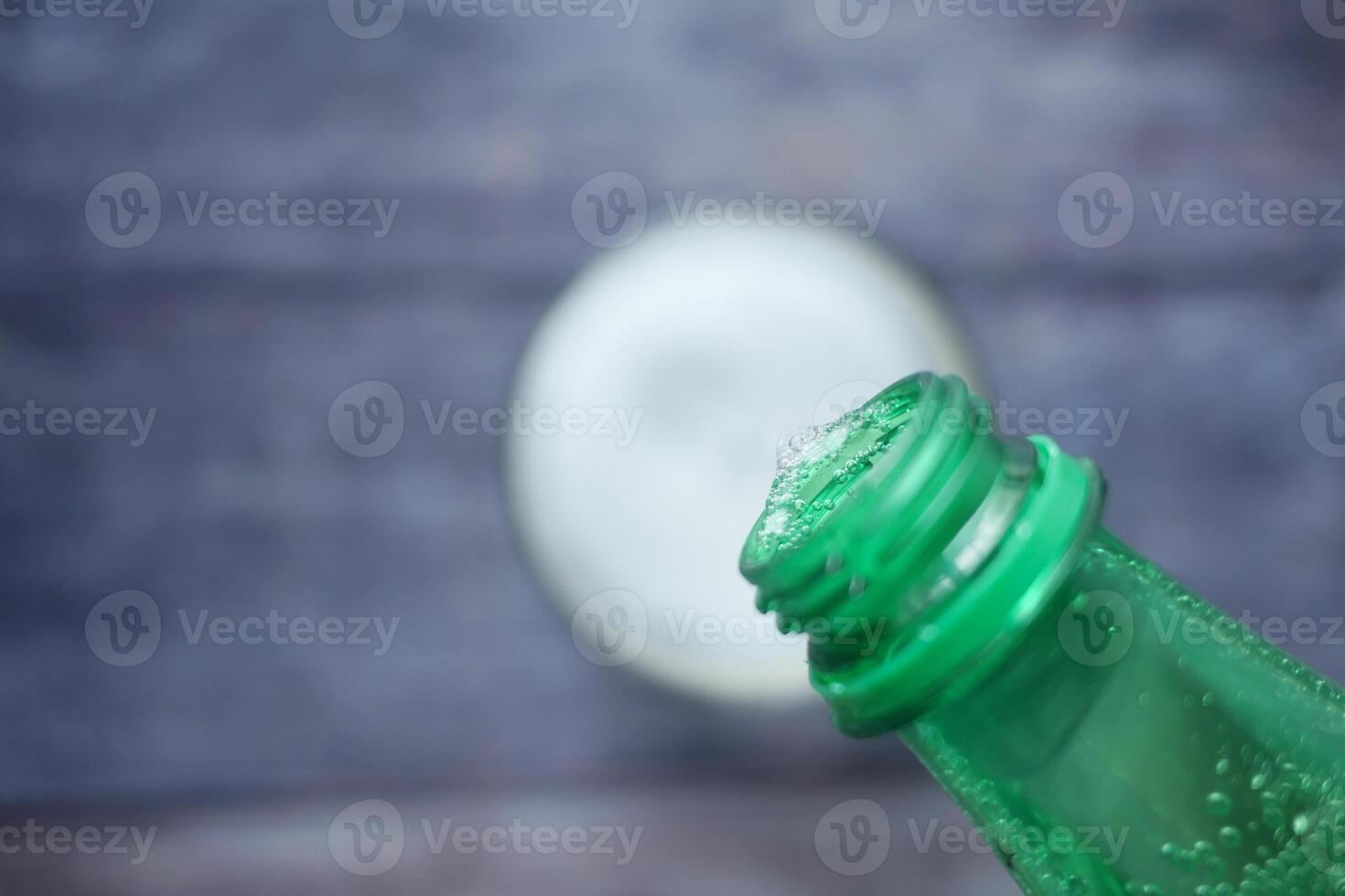 pouring soft drinks from bottle in a glass photo