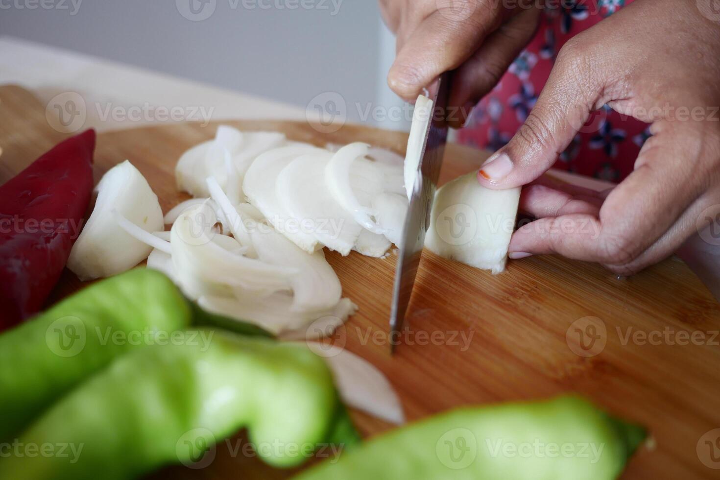 young women cutting red onion on a chopping board photo