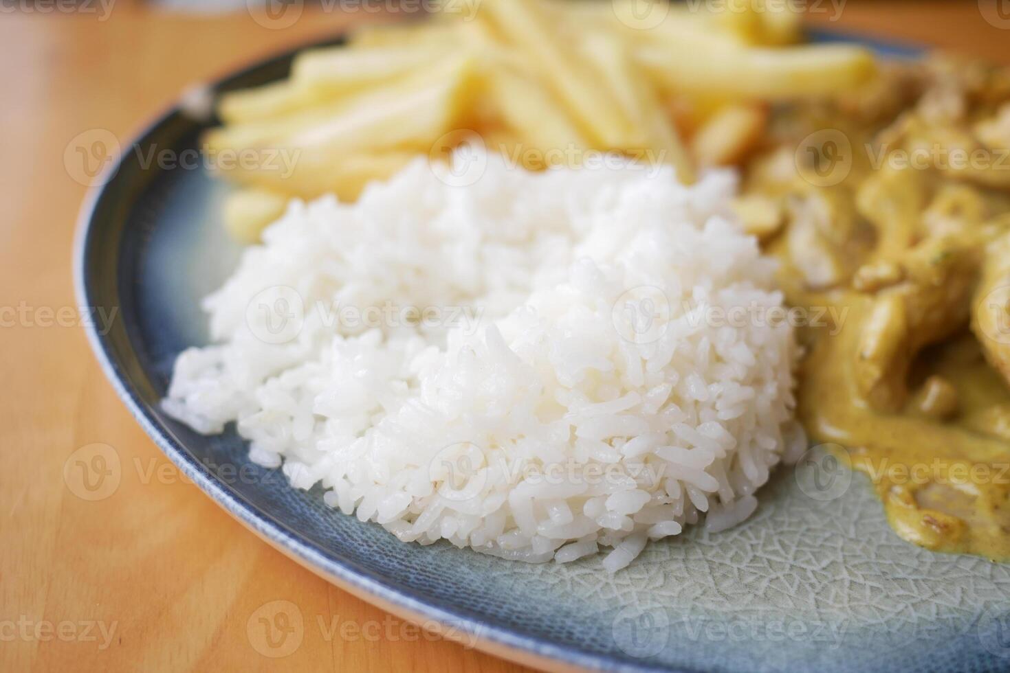 Closeup of a plate featuring white rice, French fries, and a fork, creating a delicious meal photo
