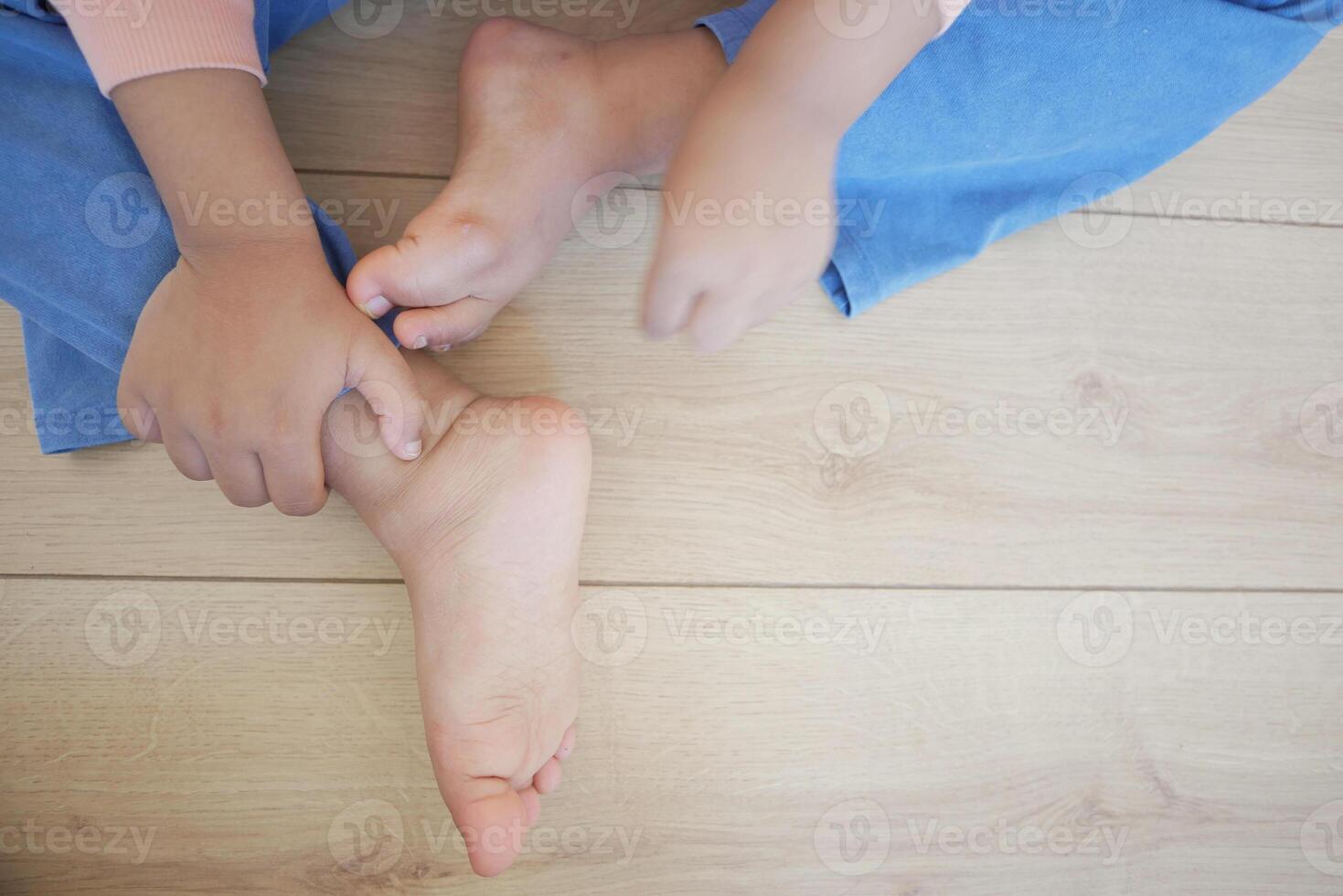 a kid suffering from itching skin on feet photo