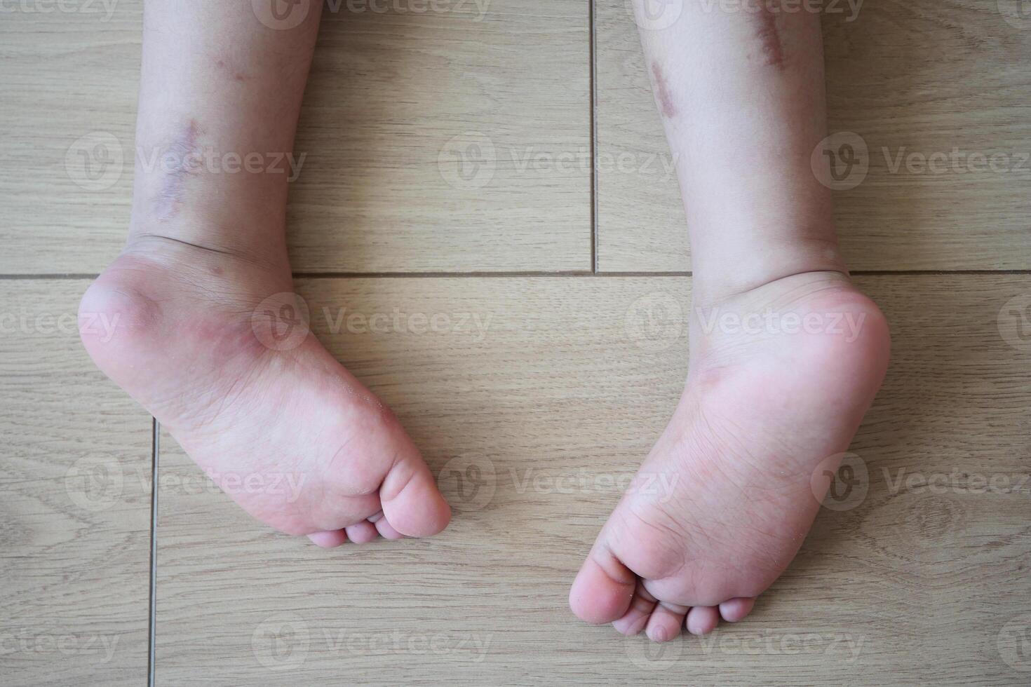 Bare feet of a child on a wooden floor represent innocence and playful moments at home photo