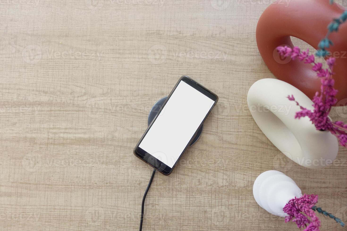 charging Smartphone using Wireless Charging Pad, top view photo