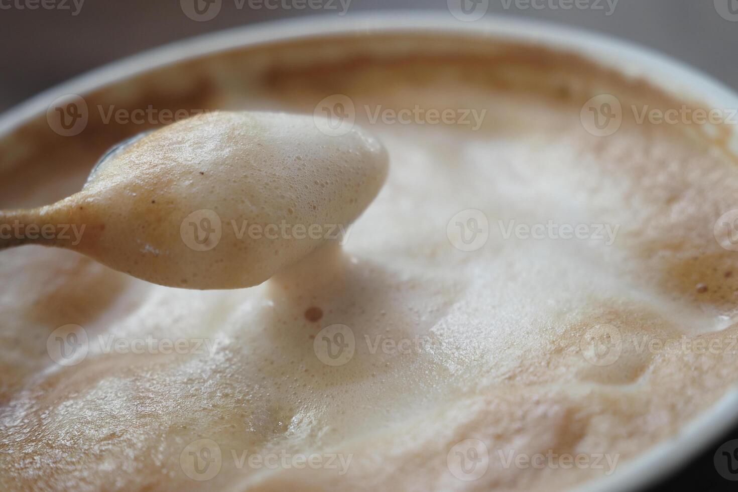 A detailed view of a frothy cappuccino with foam, ideal for indulgence and relaxation photo
