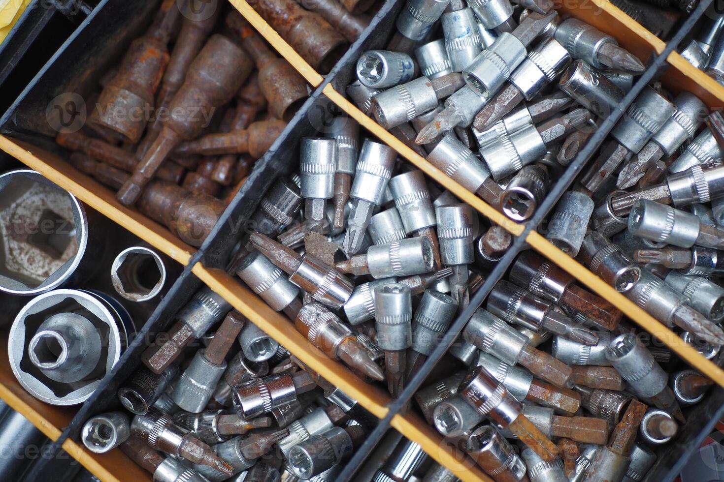 An assortment of metal nuts and bolts stored in a storage bin for construction and repair projects photo