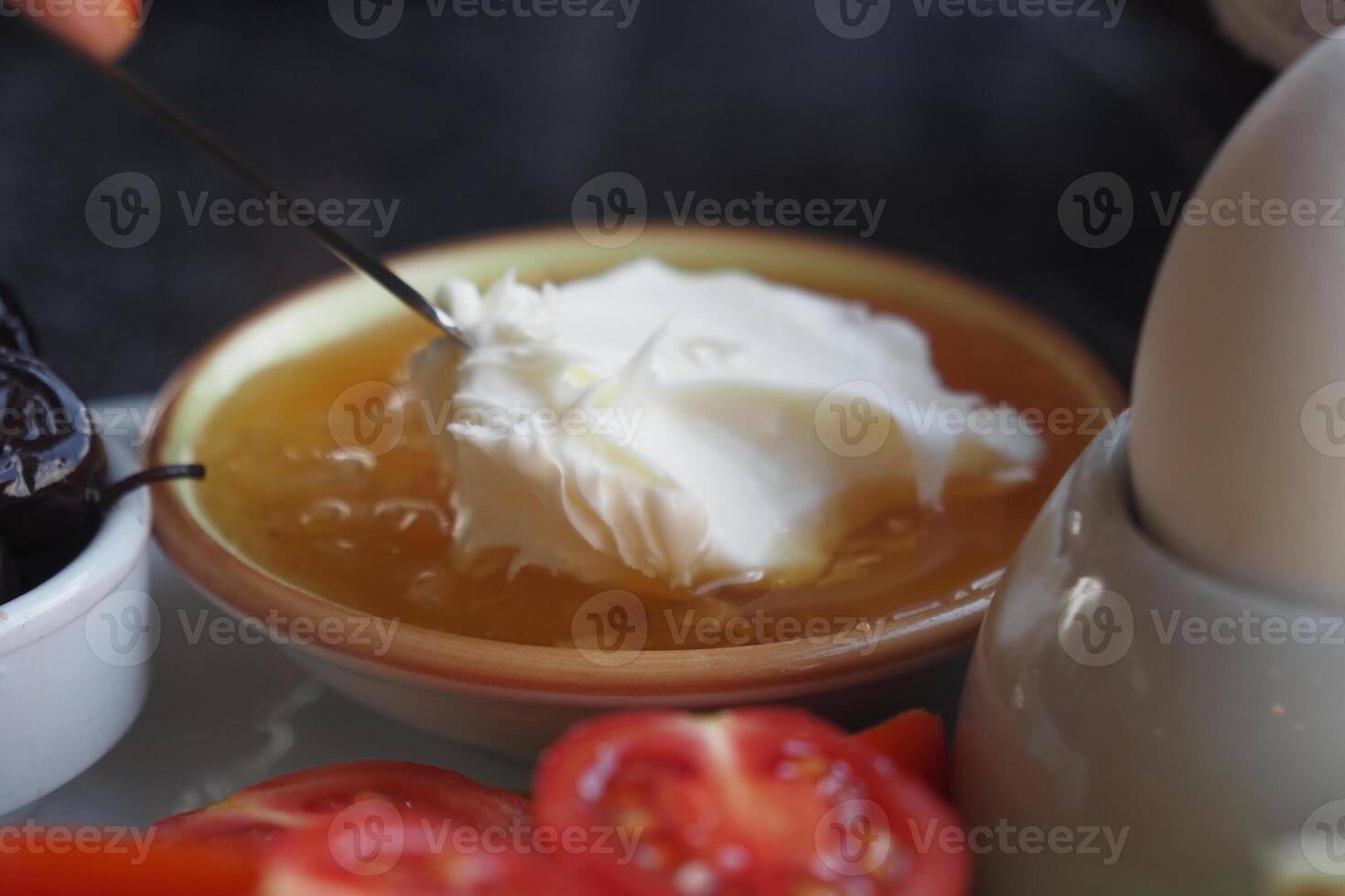 butter cream and honey in a bowl on table . photo