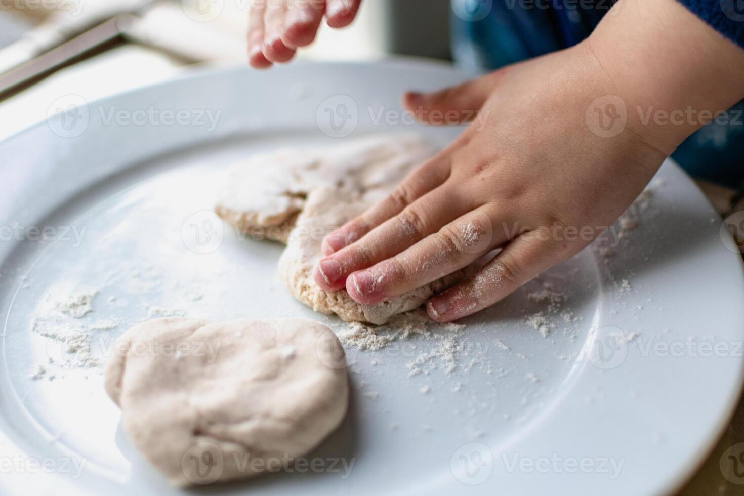 Child having fun modeling salt dough, authentic activity, fine motor skills development photo