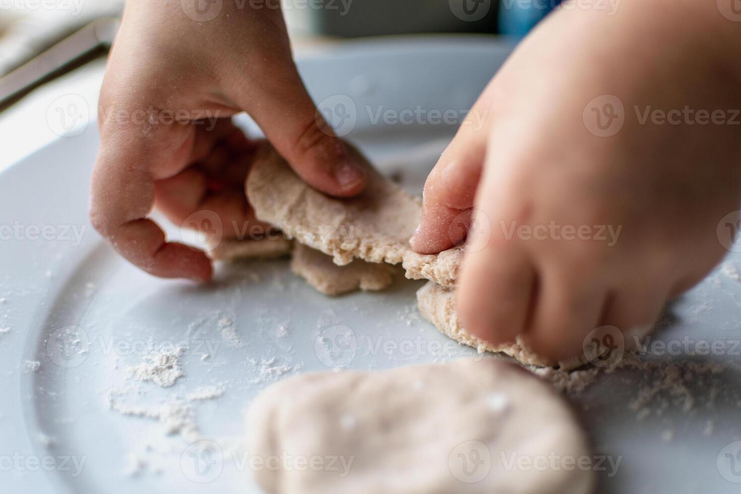 Child having fun modeling salt dough, authentic activity, fine motor skills development photo