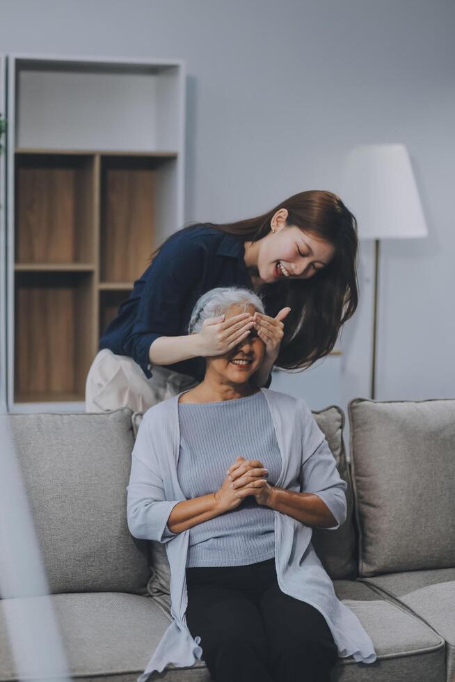 Adult daughter old mom hugging sit on couch enjoy pleasant positive talk, remembering funny occasion from life spend weekend together, caring about older generation relatives express attention concept photo