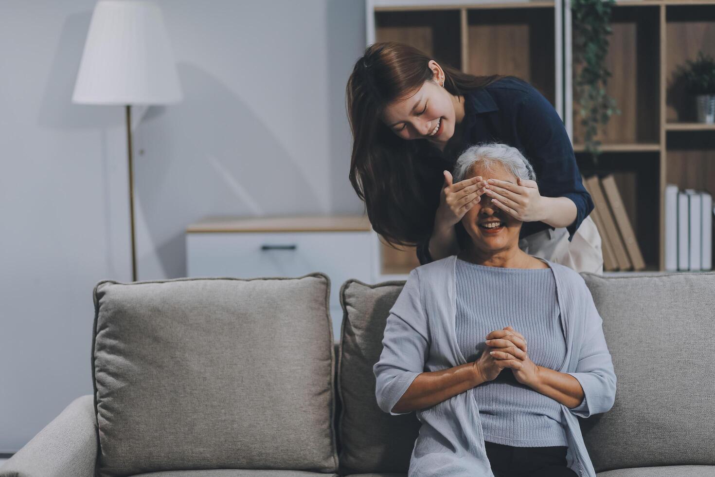 Adult daughter old mom hugging sit on couch enjoy pleasant positive talk, remembering funny occasion from life spend weekend together, caring about older generation relatives express attention concept photo