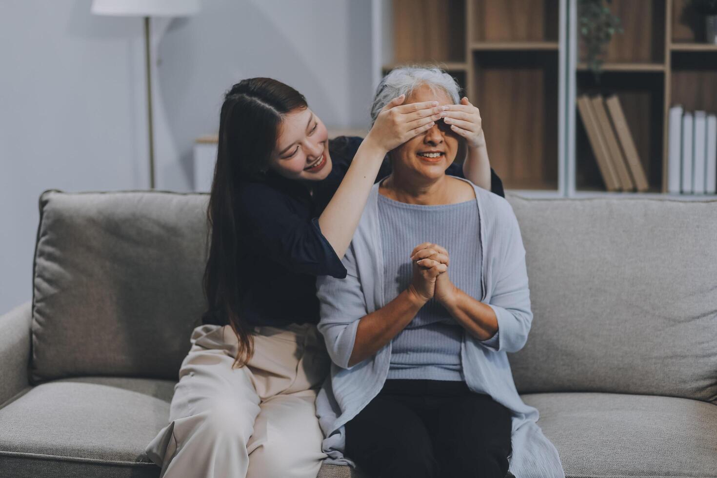 Adult daughter old mom hugging sit on couch enjoy pleasant positive talk, remembering funny occasion from life spend weekend together, caring about older generation relatives express attention concept photo