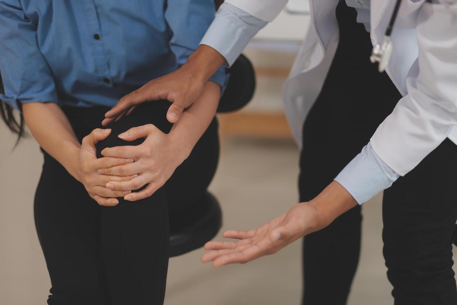 Professional orthopedist examining the little patient's leg in the clinic. Patient at the physiotherapy doing physical exercises with his therapist photo