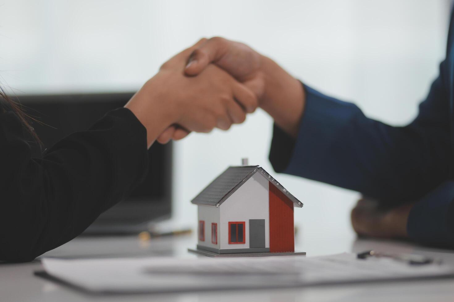 Estate agent shaking hands with customer after contract signature photo