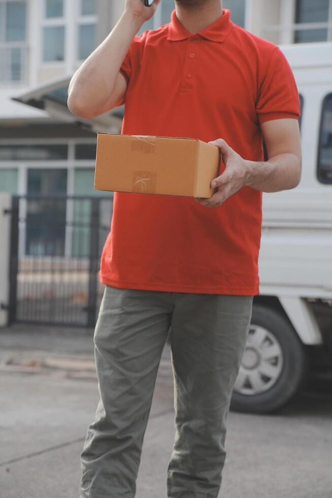 Asian delivery express courier young man use giving boxes to woman customer he wearing protective face mask at front home photo