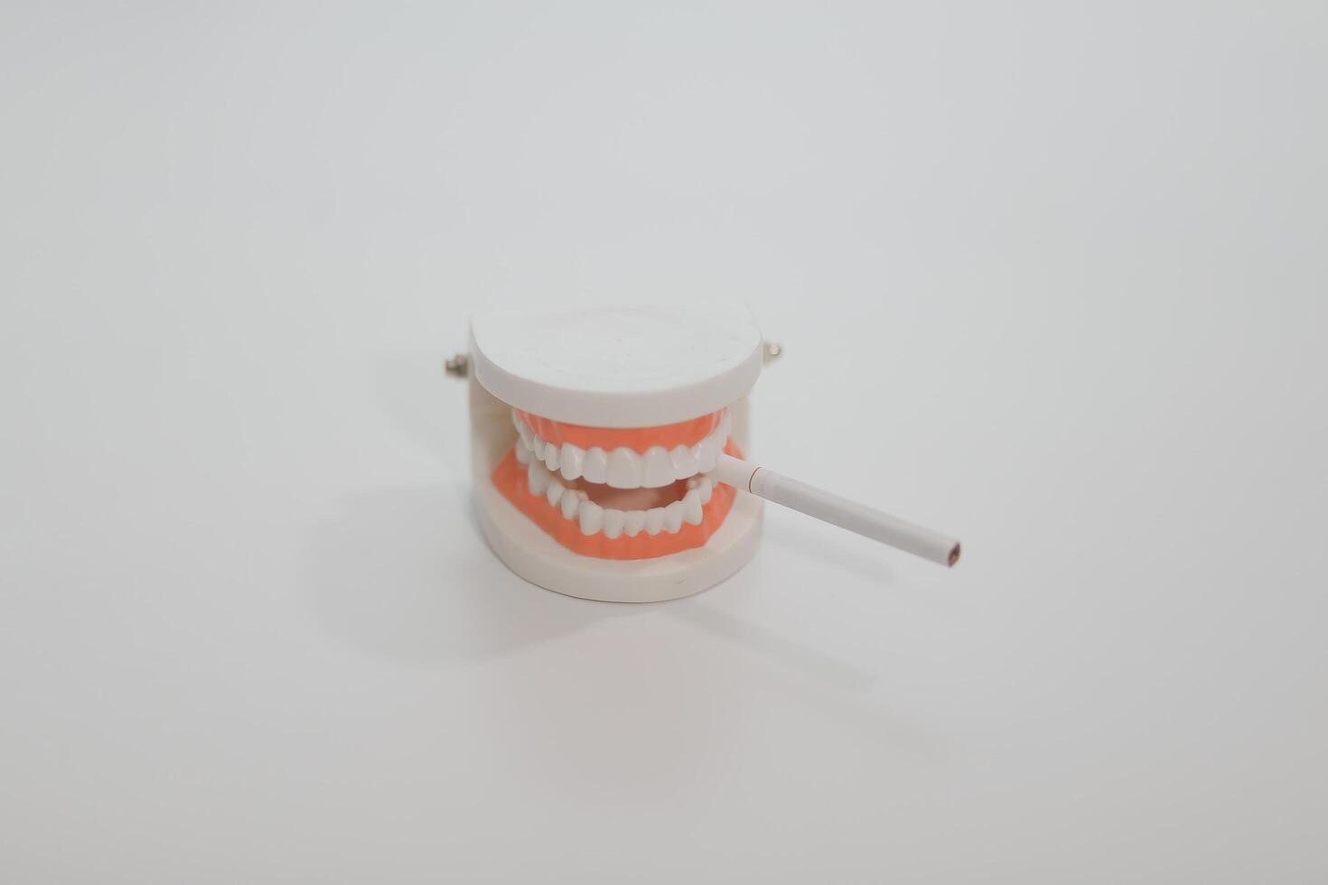 Ashtray in the form of a tooth with a stub on a white background photo