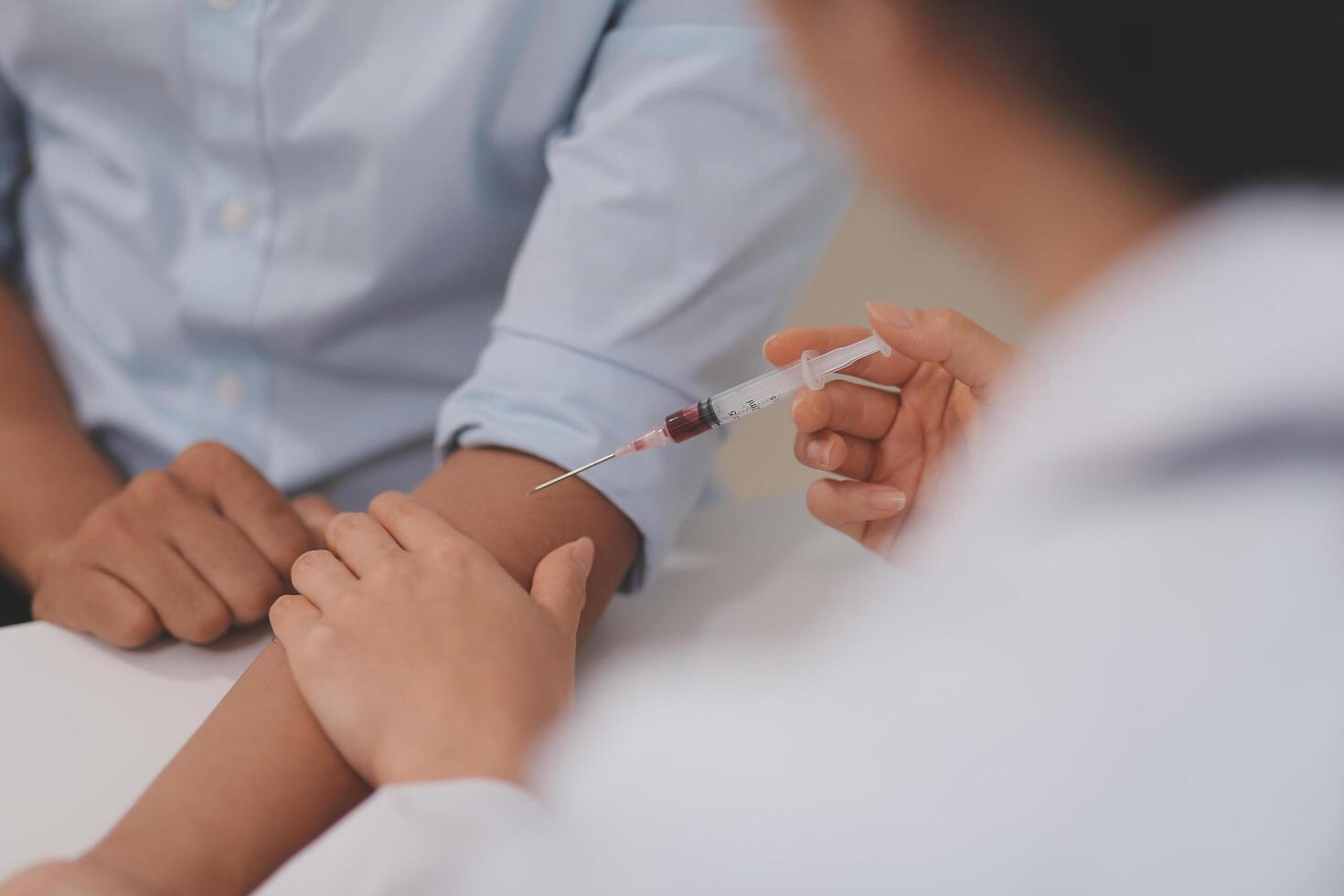 Doctor uses hypodermic needle and syringe to put a dose of medicine as treatment. photo