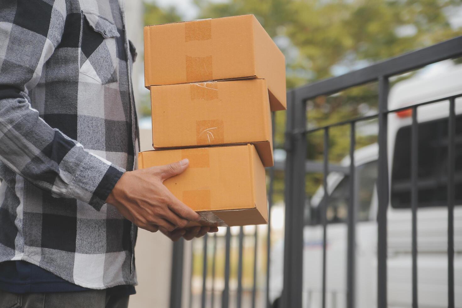 Asian delivery express courier young man use giving boxes to woman customer he wearing protective face mask at front home photo
