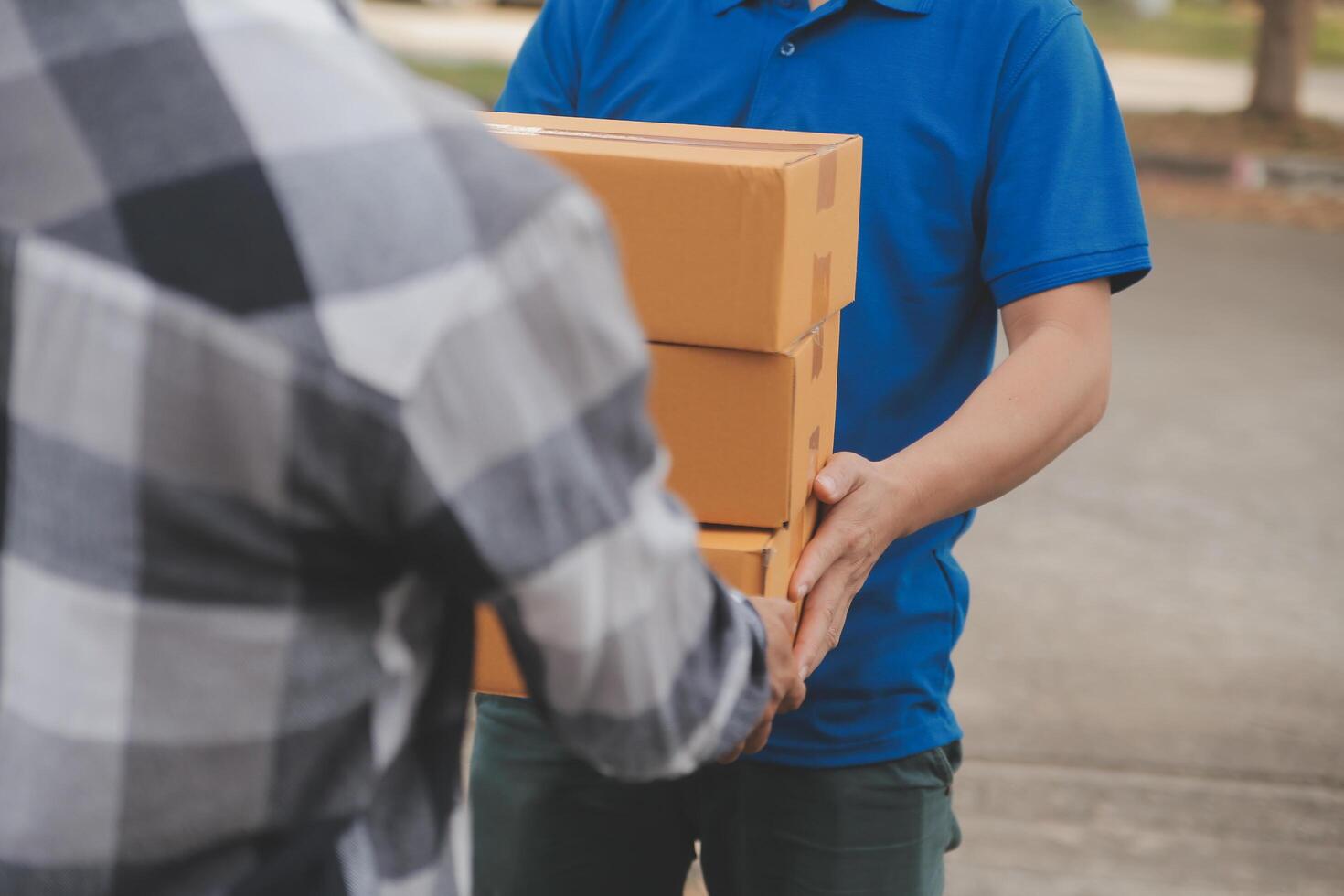 Asian delivery express courier young man use giving boxes to woman customer he wearing protective face mask at front home photo