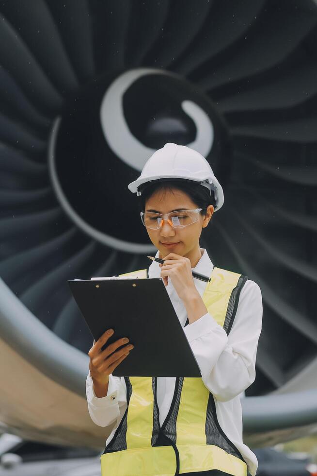 Technician fixing the engine of the airplane,Female aerospace engineering checking aircraft engines,Asian mechanic maintenance inspects plane engine photo