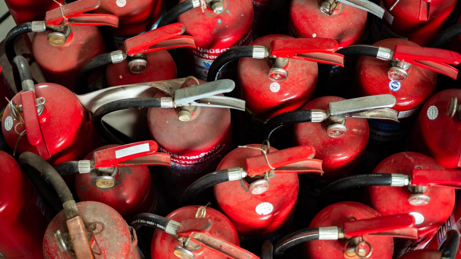 Many red fire extinguishers are placed on the ground, prepared for fire incidents, fire extinguishing equipment, disaster prevention photo