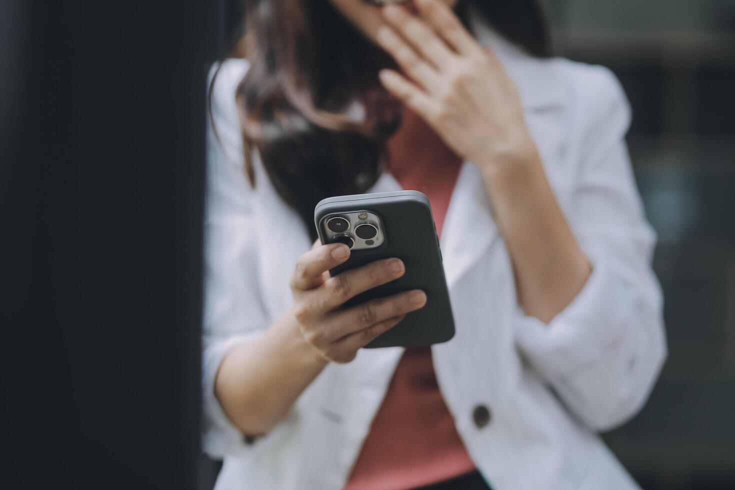 Portrait of a happy Asian businesswoman using mobile phone indoor, Asian businesswoman working in modern office. photo