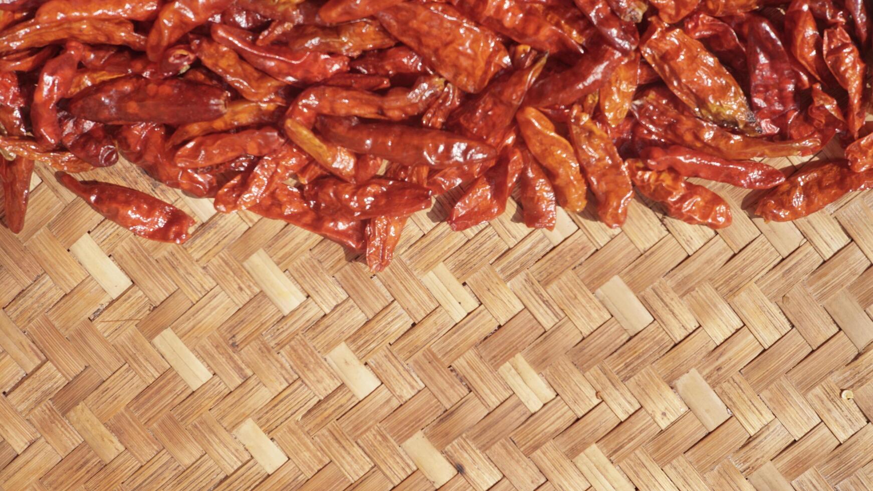 Close up small dried chilies dried in the sun on a bamboo tray photo