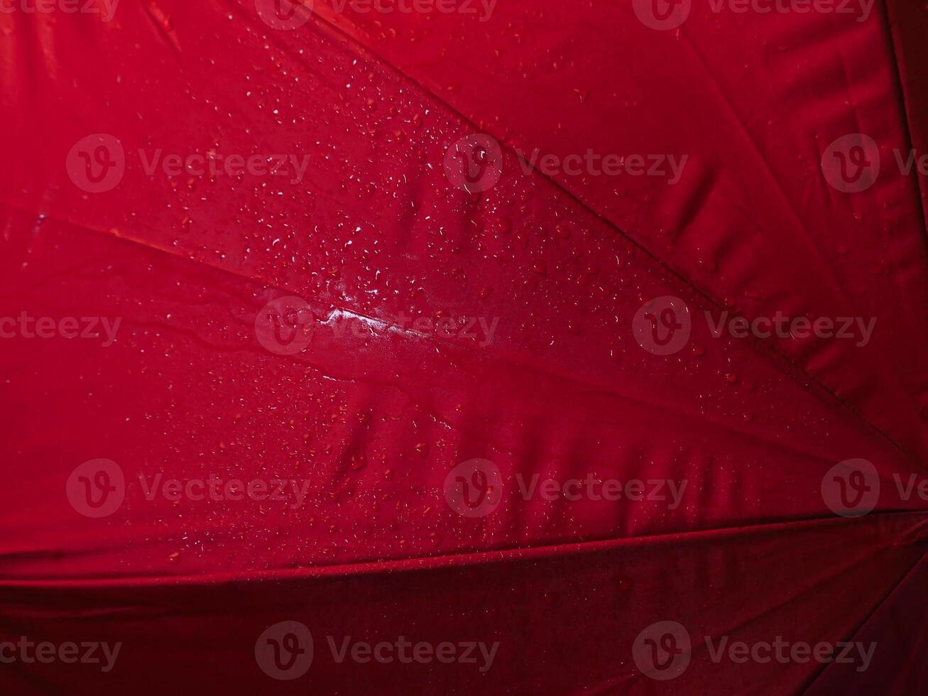 Red umbrella texture with water drops in dark for background. photo