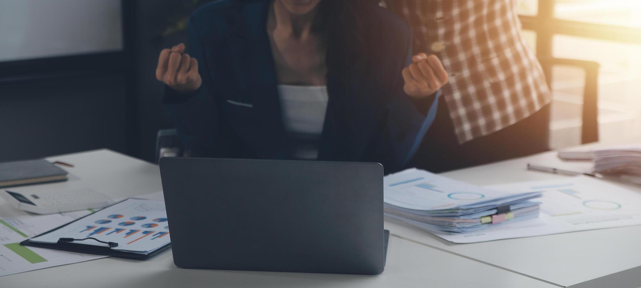 Group of confident business people point to graphs and charts to analyze market data, balance sheet, account, net profit to plan new sales strategies to increase production capacity. photo