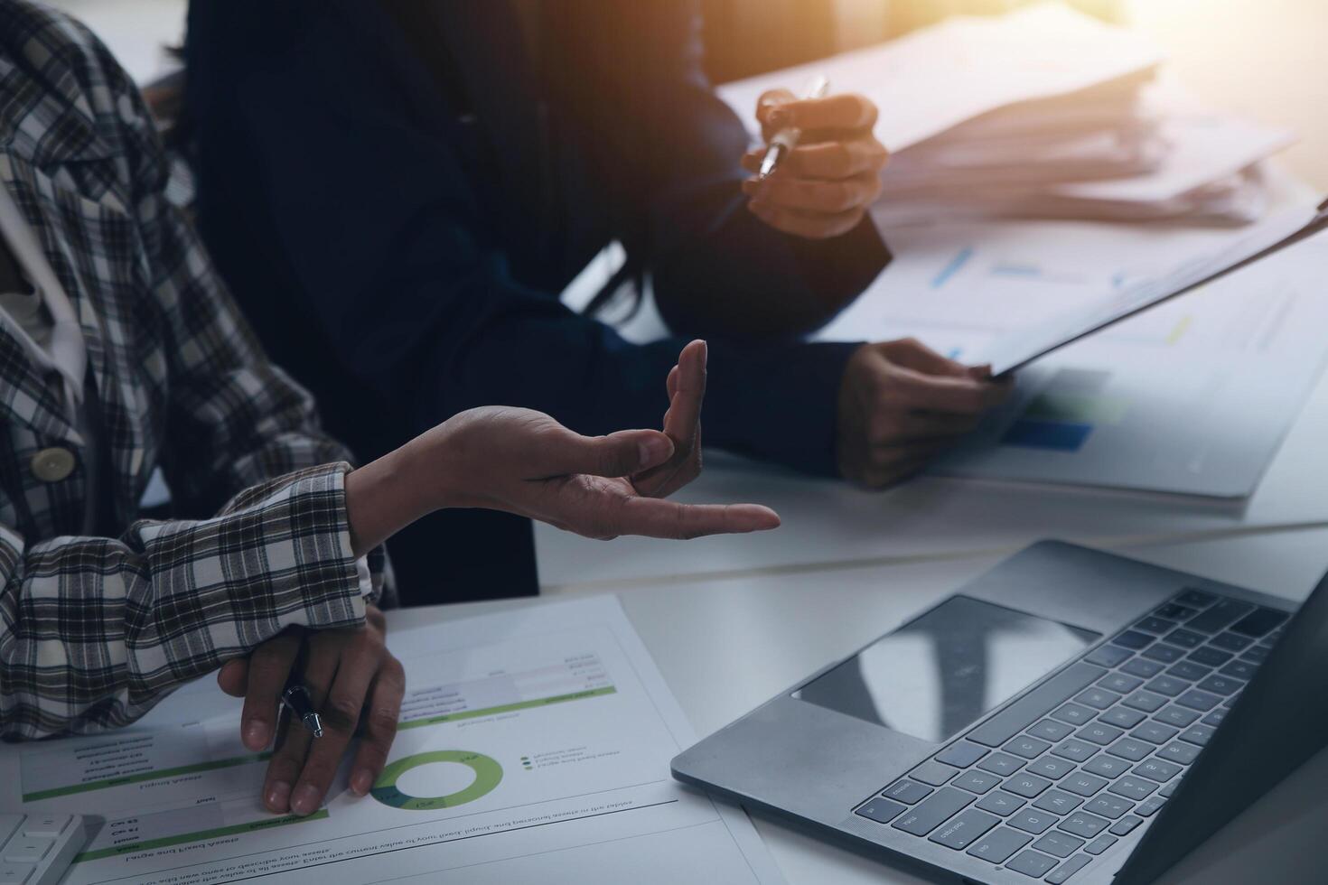 Group of confident business people point to graphs and charts to analyze market data, balance sheet, account, net profit to plan new sales strategies to increase production capacity. photo