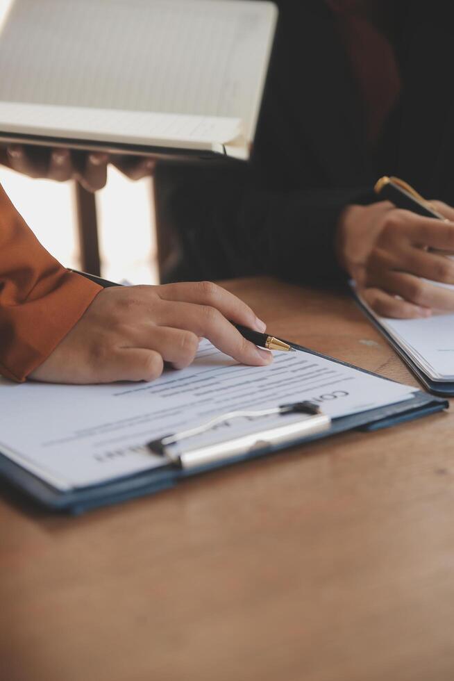Lawyer, legal advisor, businessman brainstorming information on agreement details Business contracts in legal processing books for accuracy in contract documents. joint financial investment. photo
