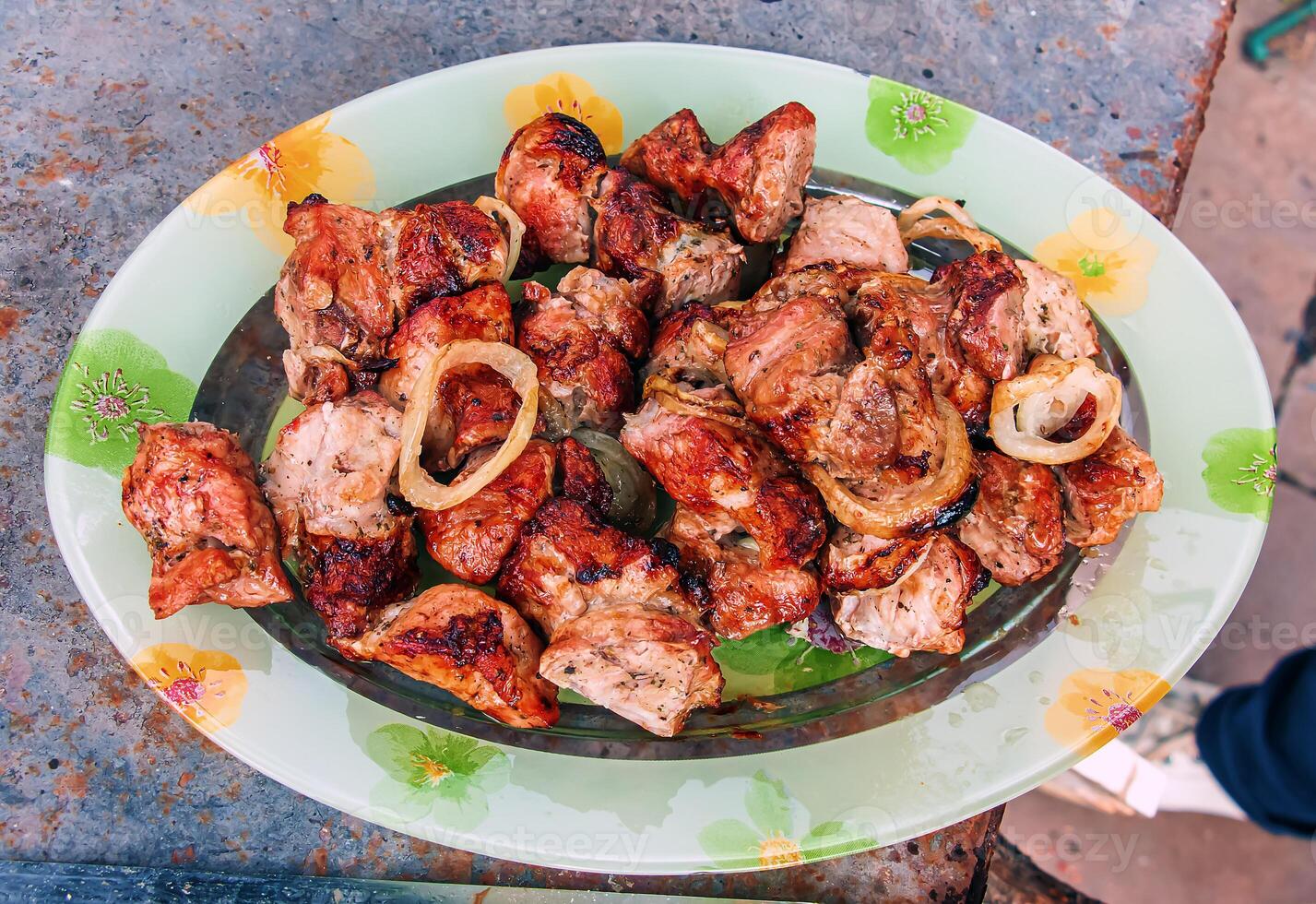 Cooked kebabs on the grill with smoke. Fresh brown BBQ meat cooked on an outdoor grill photo