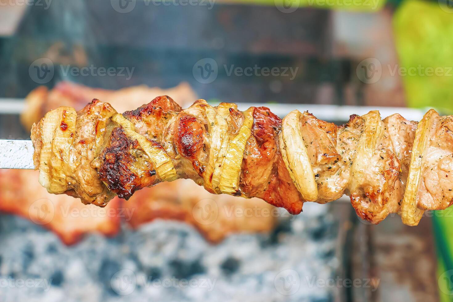Cooking kebabs on a grill with smoke. Fresh brown BBQ meat cooked on an outdoor grill photo