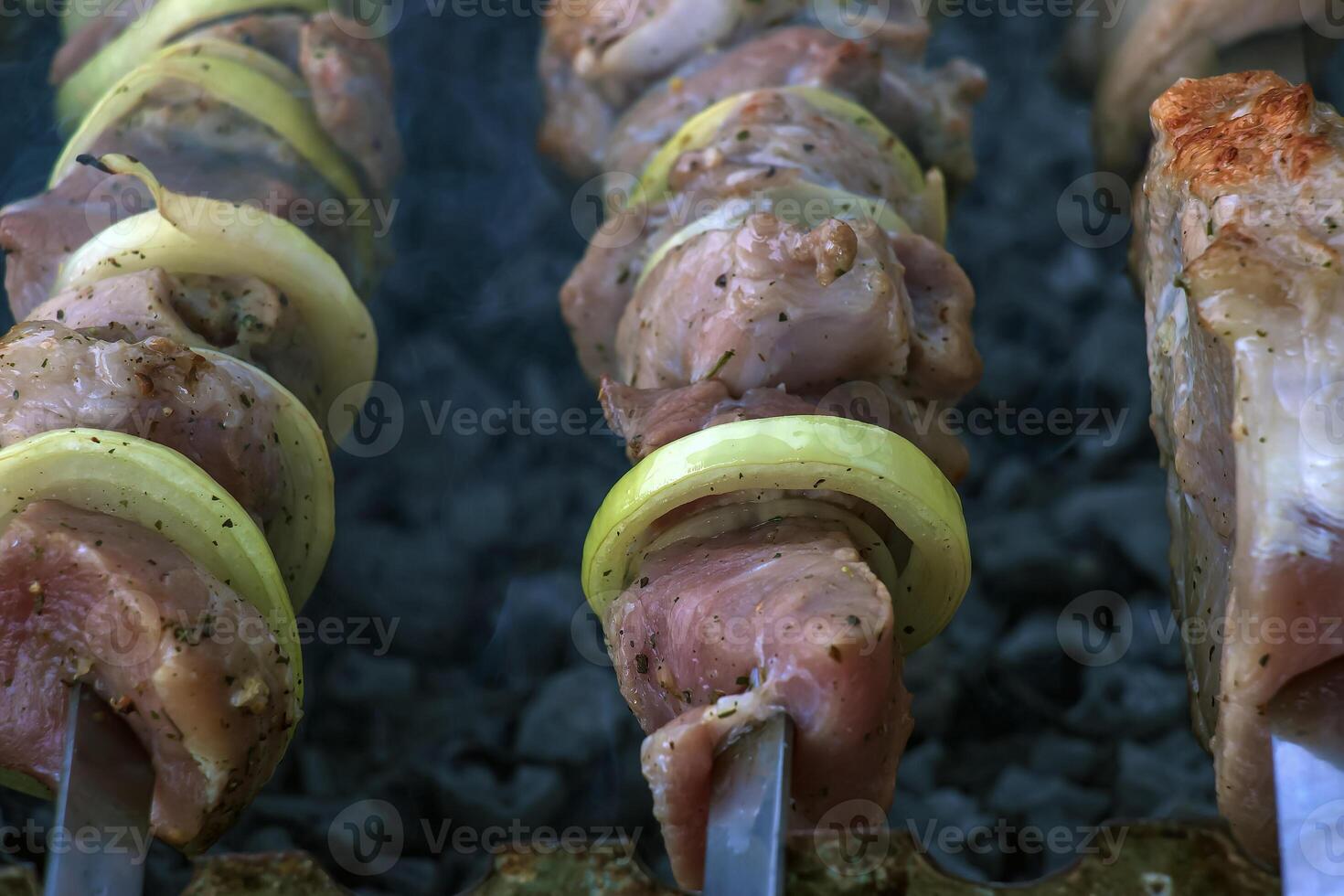 Cooking kebabs on a grill with smoke. Fresh brown BBQ meat cooked on an outdoor grill photo
