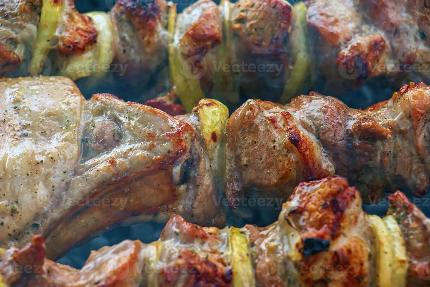 Cooking kebabs on a grill with smoke. Fresh brown BBQ meat cooked on an outdoor grill photo