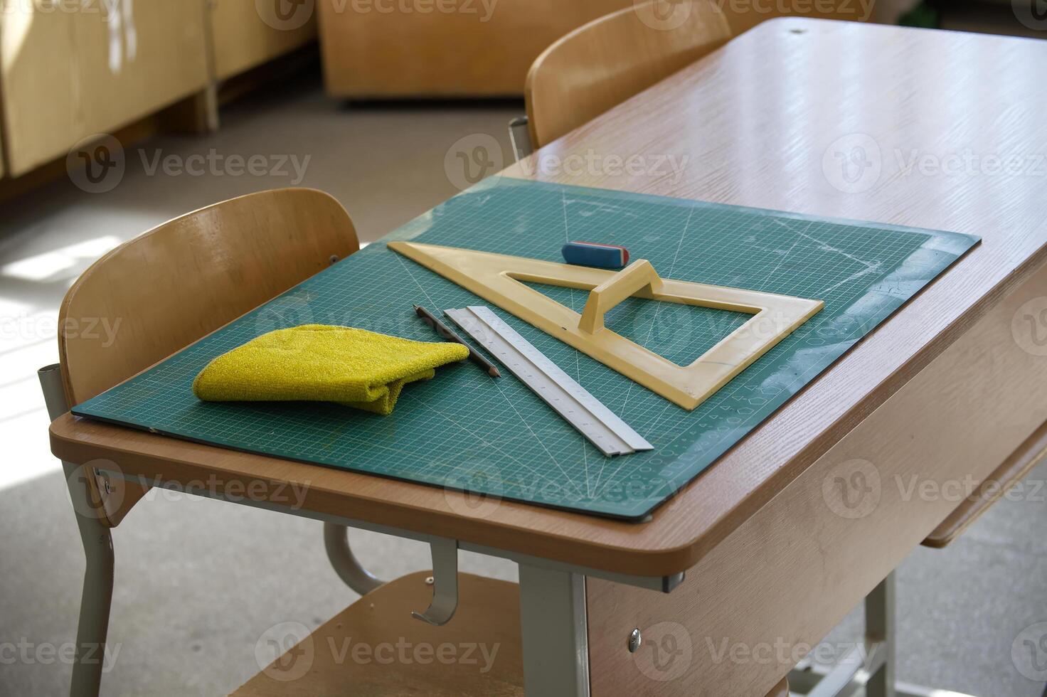 Classroom desk with math tools, ruler, and eraser on a cutting mat photo