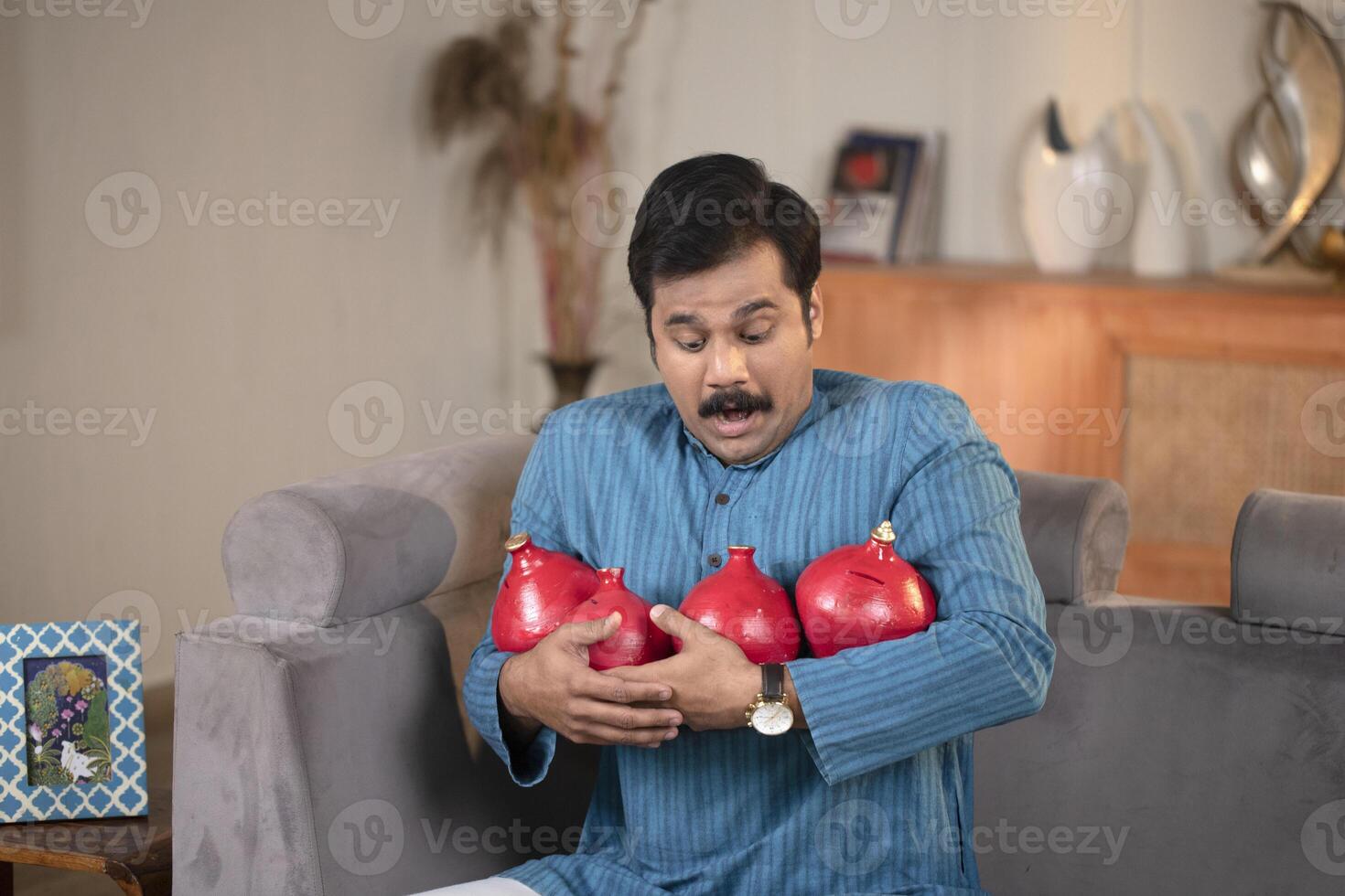 Mature Guy Posing With Clay Piggy Bank In Front Of Camera photo