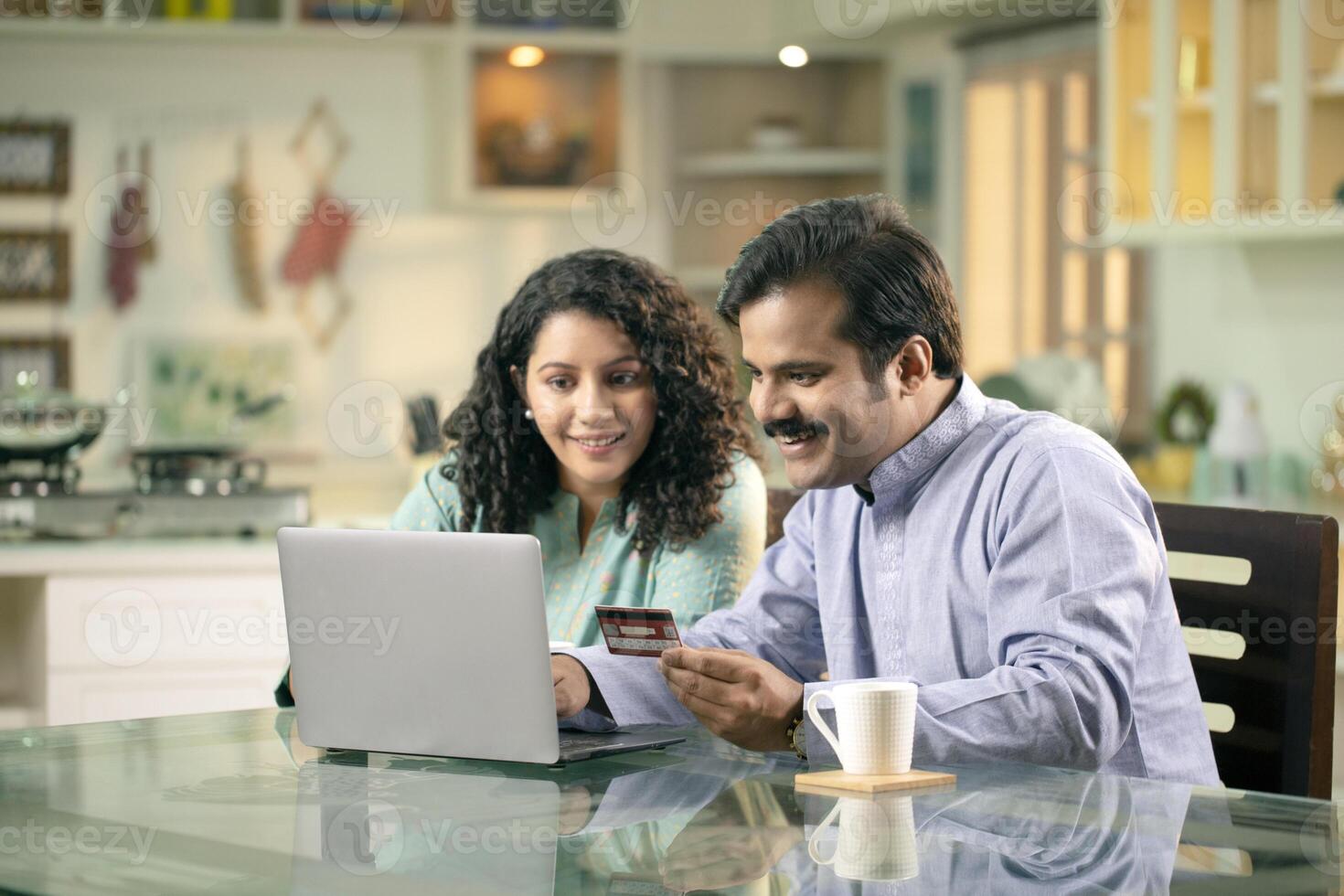 Happy Couple Using Credit Card While Shopping Online Through Laptop At Home photo