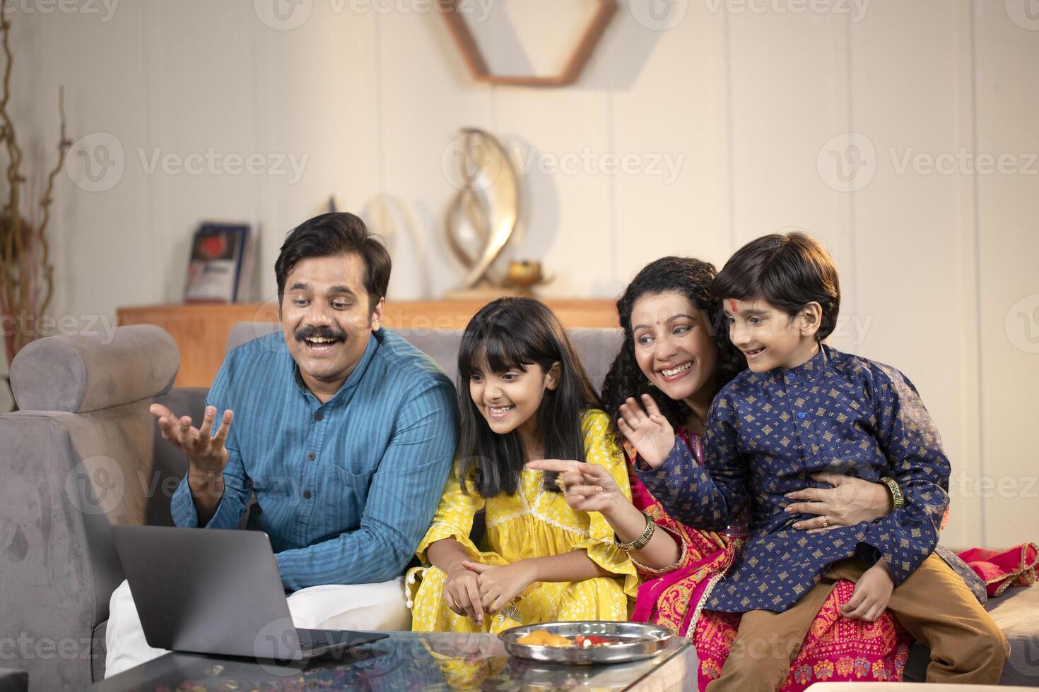 Blissful Family In Front Of Laptop Smiling And Waving Hands photo