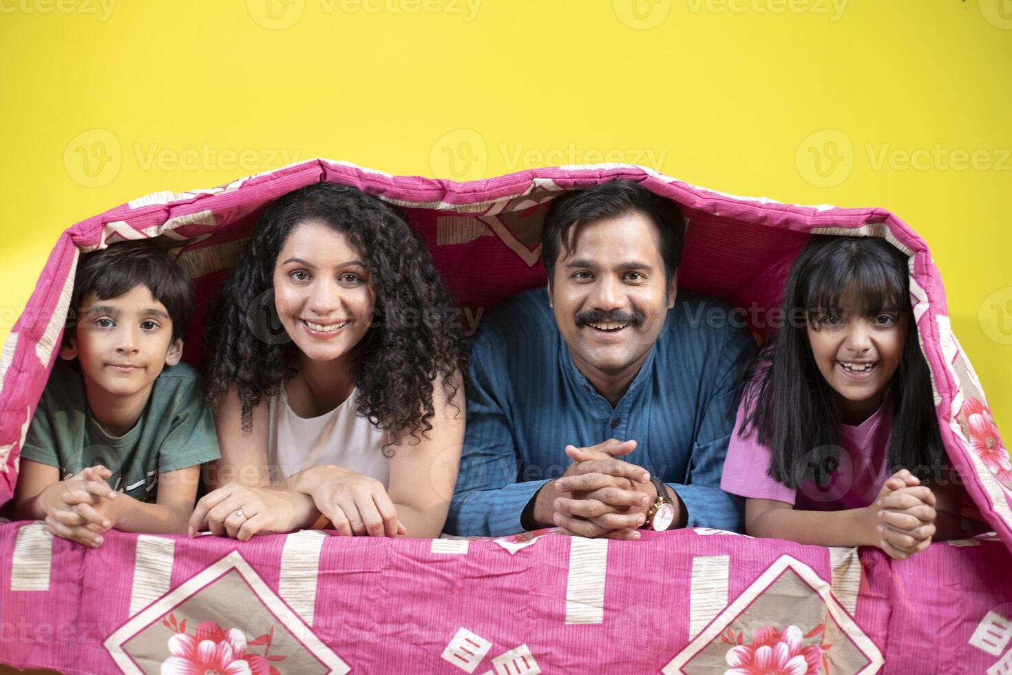 Playful Family With Children In Bed Under A Blanket photo