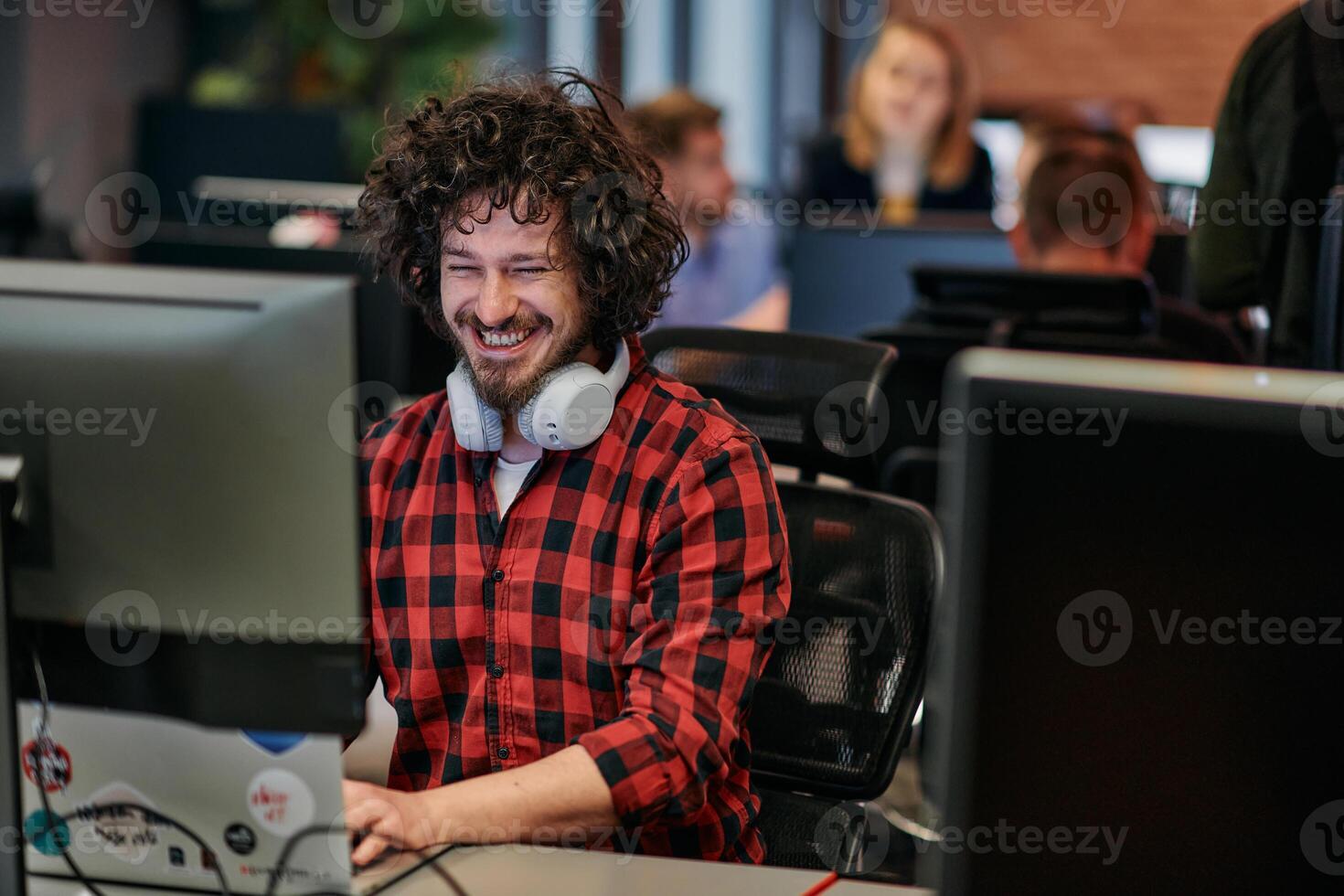 Focused Programmer With Afro Hairstyle in Plaid Shirt Working on Computer in Office Environment photo
