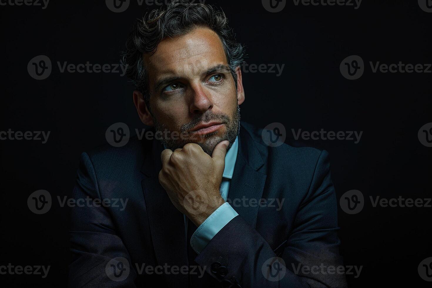Portrait of a businessman thinking with one hand on his chin looking at camera. Business, curiosity, planning, feasibility analysis, solving problem, finding solution photo