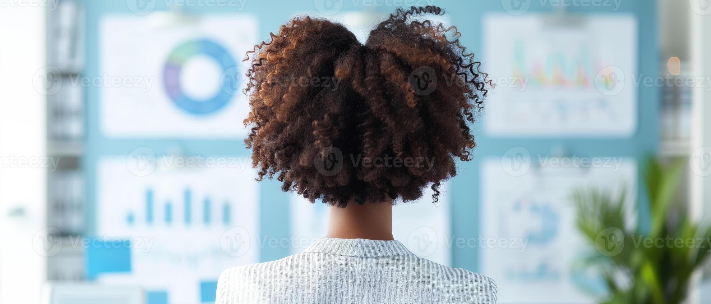 Woman analyzing charts, graphs, and data on a wall. Business and data analysis concept with charts and graphs in background. photo