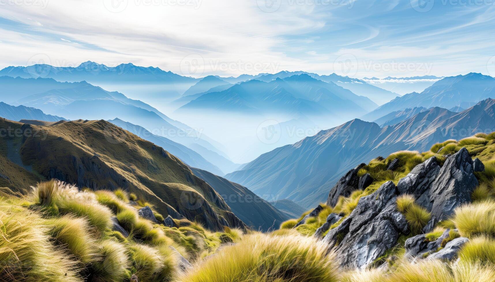 Breathtaking mountain landscape with rolling hills and misty valleys under a clear blue sky, perfect for nature and adventure enthusiasts. photo