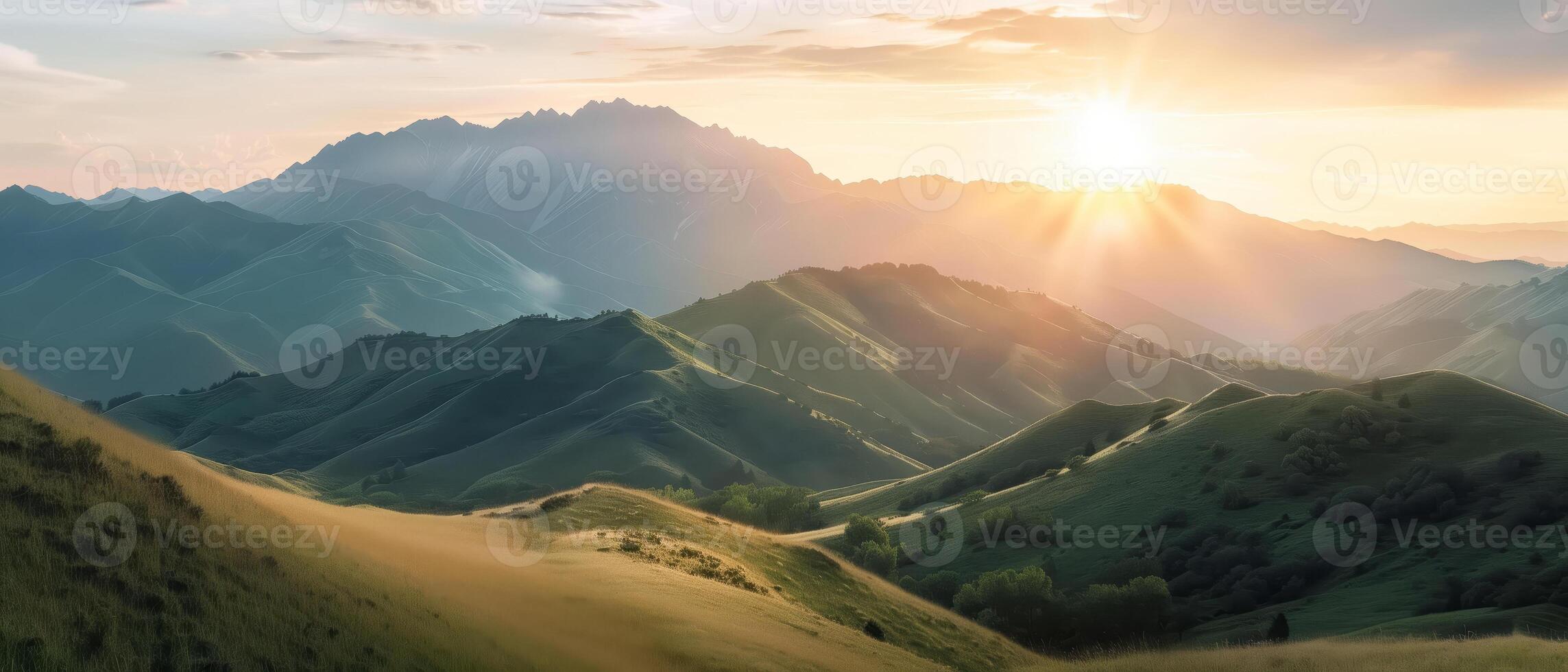 Scenic view of rolling hills and mountains during sunset, with sun rays illuminating the landscape and casting shadows on the slopes. photo
