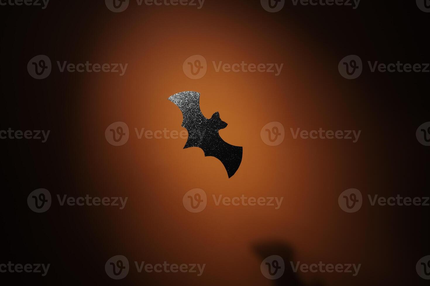Glitter paper bat in spotlight Halloween background photo