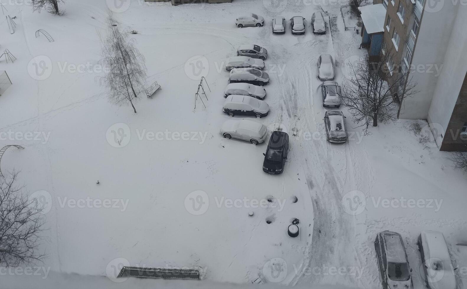Cars in the snow top view. snow-covered paths and trees photo